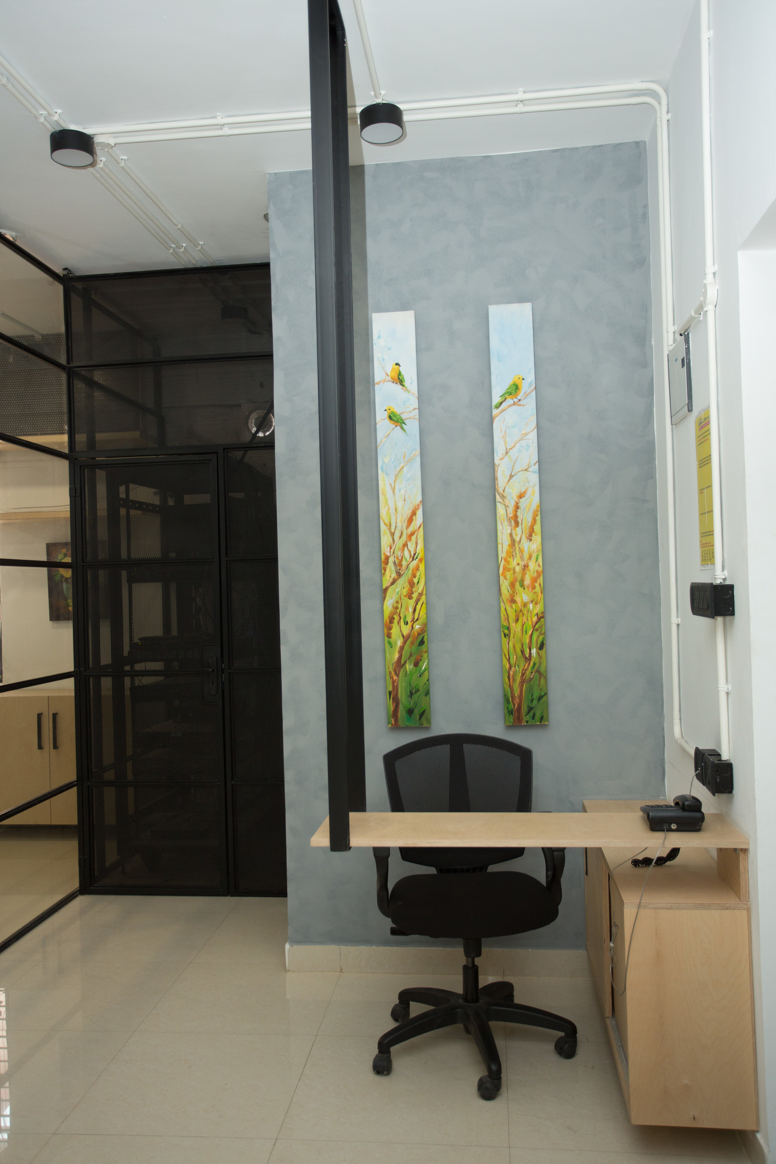 A sleek ceiling hung reception table placed at the entrance, with side sliding storage boxes. The server room is visible at the back!