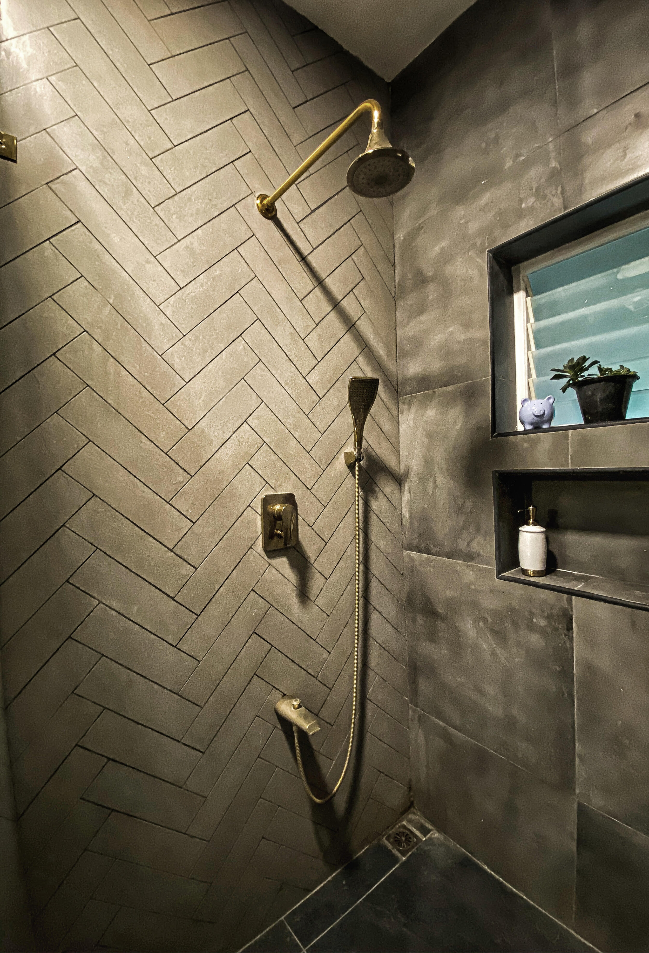 HOLY HERRINGBONE! We custom chose the tile, color and size we wanted for the herringbone patterned tile feature wall. By using a precise water jet cutting technique we got the desired effect we wanted. A darker grey epoxy grout brings out the pattern and tile formation of this gorgeous shower wall.
